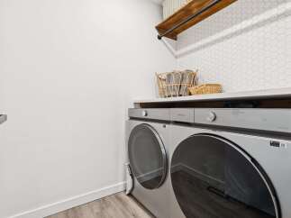 This modern laundry room features a sleek Samsung washer and dryer set, perfect for handling large loads.