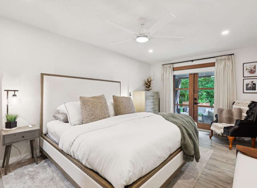 Experience ultimate comfort in this luxurious master bedroom, featuring a king-sized bed with plush bedding and a stylish upholstered headboard.