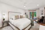 Experience ultimate comfort in this luxurious master bedroom, featuring a king-sized bed with plush bedding and a stylish upholstered headboard.