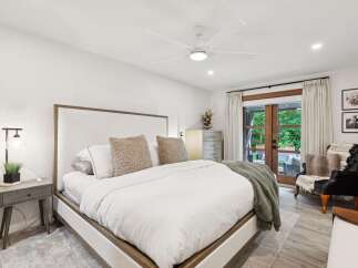 Experience ultimate comfort in this luxurious master bedroom, featuring a king-sized bed with plush bedding and a stylish upholstered headboard.