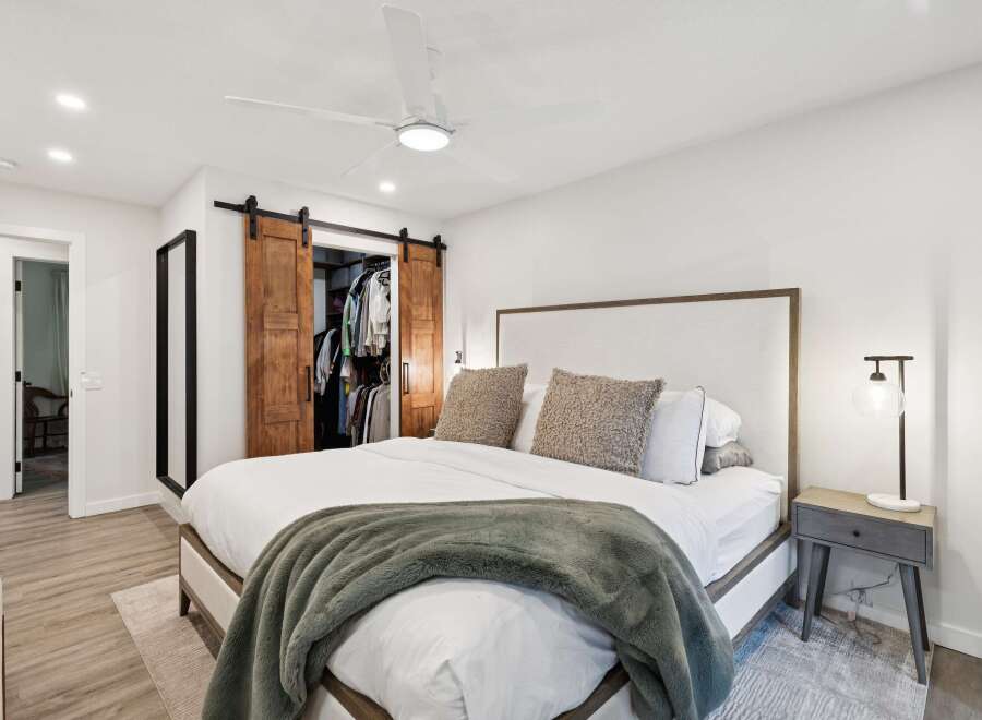Experience ultimate comfort in this master bedroom, featuring a plush king-sized bed adorned with a cozy green throw blanket.