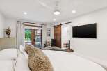Experience modern luxury in this master suite featuring a king-sized bed with plush bedding and a cozy textured throw.