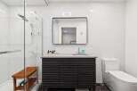 Experience modern luxury in this stunning bathroom featuring a sleek vanity with ample storage and a minimalist aesthetic.