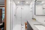Experience luxury in this modern bathroom featuring a spacious walk-in shower with marble-look tiles and a rainfall showerhead.