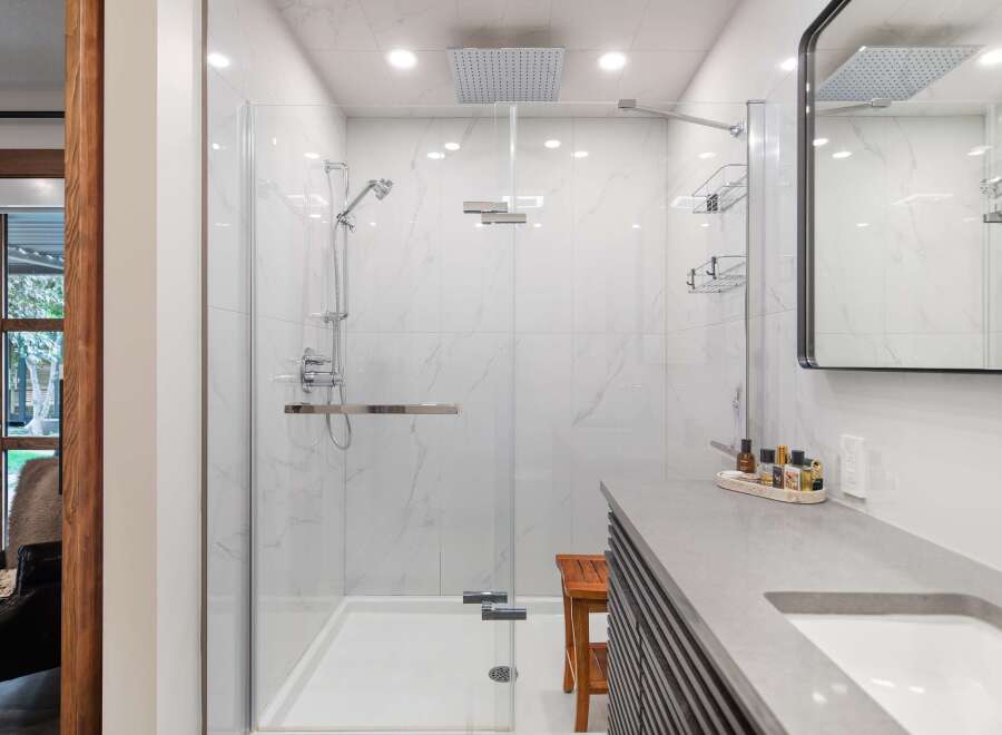 Experience luxury in this modern bathroom featuring a spacious walk-in shower with marble-look tiles and a rainfall showerhead.