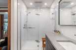 Experience luxury in this modern bathroom featuring a spacious walk-in shower with marble-look tiles and a rainfall showerhead.