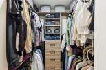 Discover organized living with this spacious walk-in closet, featuring ample hanging space and neatly stacked shelves for clothing and accessories.