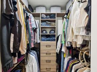 Discover organized living with this spacious walk-in closet, featuring ample hanging space and neatly stacked shelves for clothing and accessories.
