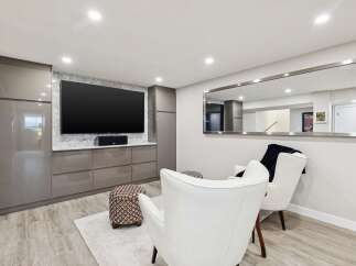 This modern living space features a sleek entertainment center with ample storage and a large flat-screen TV, perfect for movie nights.