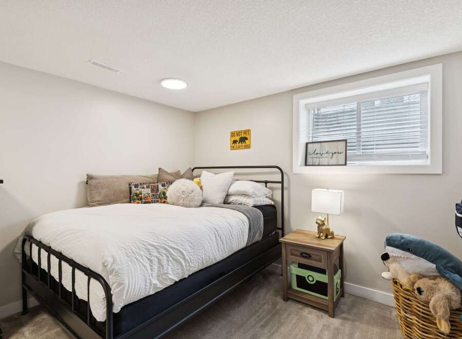 This charming bedroom features a comfortable queen-size bed with crisp white linens, perfect for a restful night's sleep.