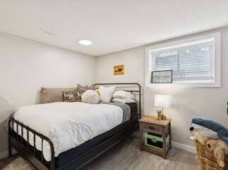 This charming bedroom features a comfortable queen-size bed with crisp white linens, perfect for a restful night's sleep.