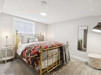 Experience comfort and style in this charming bedroom, featuring a beautiful brass bed frame adorned with a vibrant, patterned duvet.