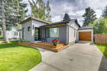Discover modern living in this beautifully renovated home featuring a sleek grey exterior and a welcoming wooden deck.