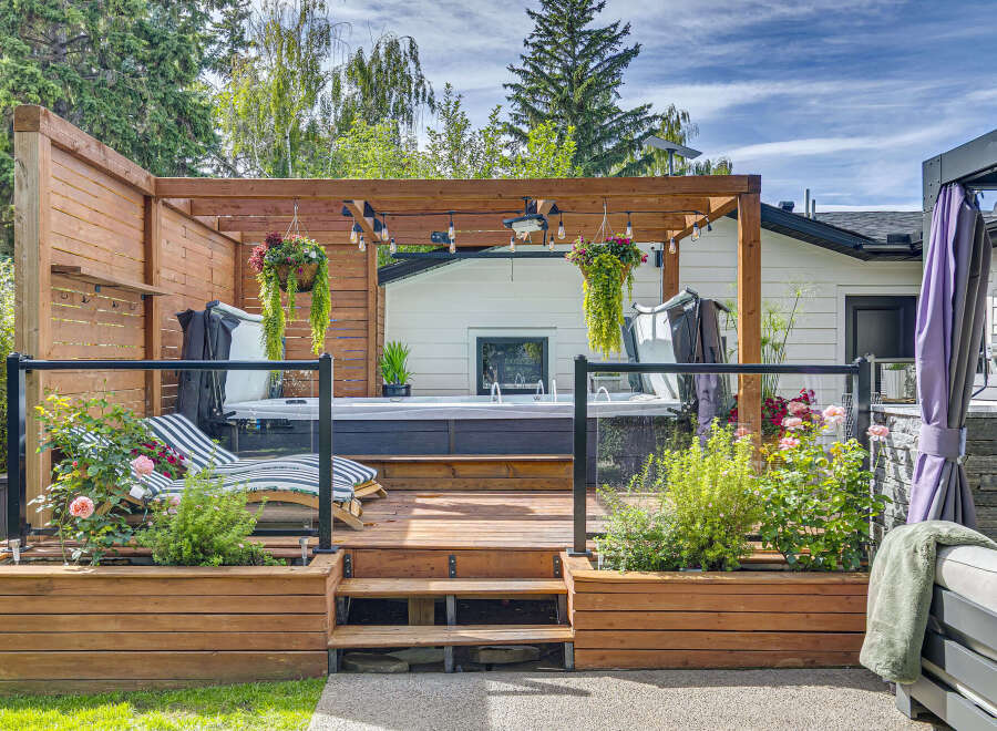 Experience ultimate relaxation in this backyard oasis, featuring a luxurious hot tub nestled on a spacious wooden deck.