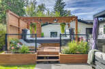 Experience ultimate relaxation in this backyard oasis, featuring a luxurious hot tub nestled on a spacious wooden deck.