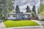 Experience modern living in this beautifully renovated home featuring a striking grey facade and crisp white siding.