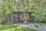 Discover this modern backyard oasis featuring a sleek, dark-finished sauna cabin with large glass windows, offering a private retreat.