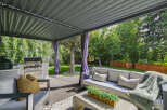 Enjoy outdoor living at its finest with this covered patio featuring a built-in grill station and comfortable seating.