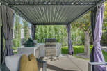 Experience outdoor living at its finest with this covered patio featuring a built-in grill and a large green egg smoker.