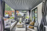 Experience luxurious outdoor living with this stunning covered patio, featuring a built-in stone fireplace and comfortable seating.