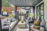 Enjoy outdoor living at its finest with this covered patio featuring a sleek outdoor kitchen and comfortable seating area.