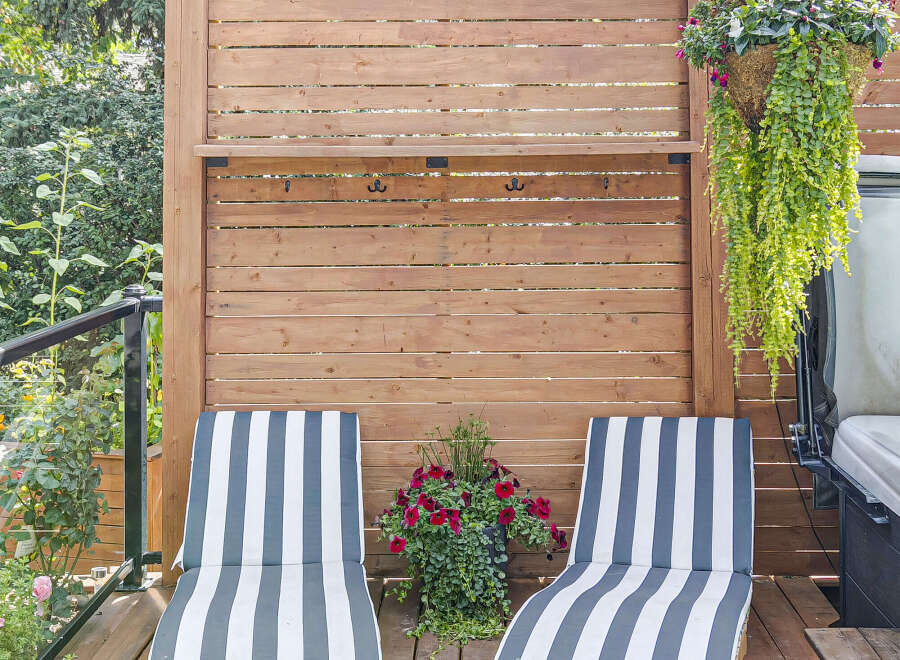 Relax and unwind on this beautiful wooden deck, featuring two comfortable striped lounge chairs perfect for soaking up the sun.