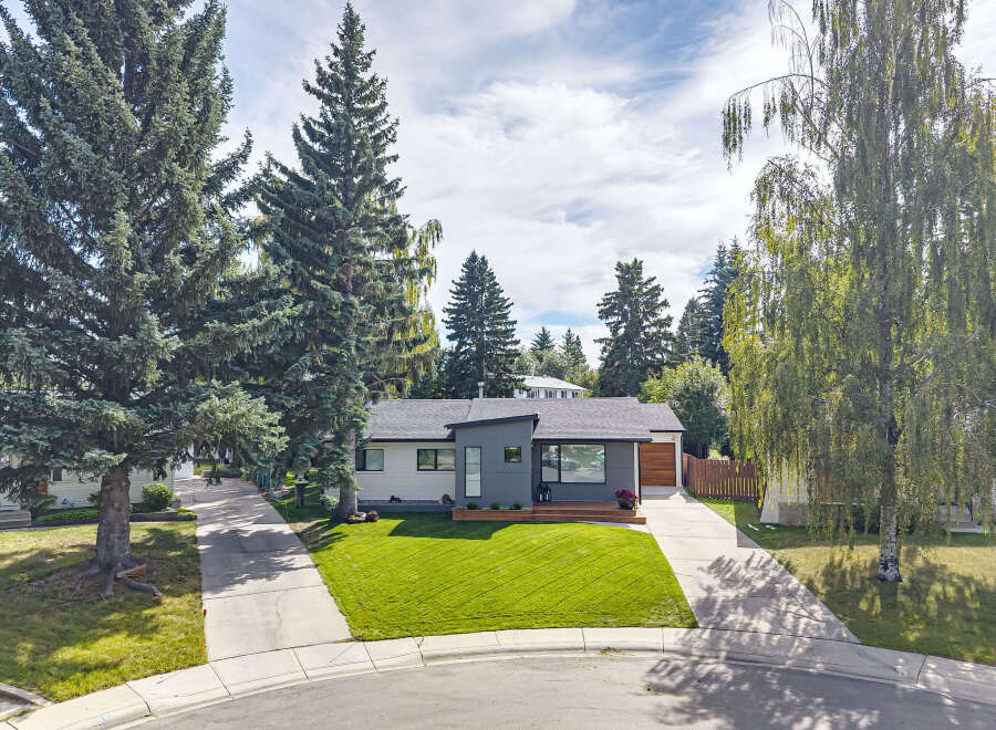 Discover modern living in this beautifully renovated home, featuring a striking grey and white facade with a sleek, angular design.