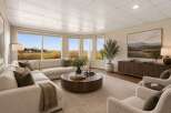 Experience breathtaking panoramic views from this stunning living room, featuring a large sectional sofa and a modern coffee table.