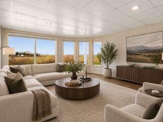 Experience breathtaking panoramic views from this stunning living room, featuring a large sectional sofa and a modern coffee table.