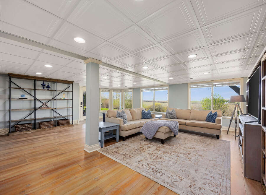 This spacious living area boasts a large sectional sofa perfect for family gatherings, complemented by a stylish area rug and a modern entertainment center.