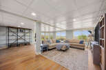 This spacious living area boasts a large sectional sofa perfect for family gatherings, complemented by a stylish area rug and a modern entertainment center.