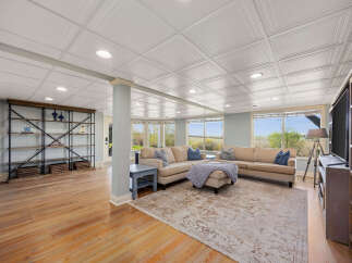 This spacious living area boasts a large sectional sofa perfect for family gatherings, complemented by a stylish area rug and a modern entertainment center.