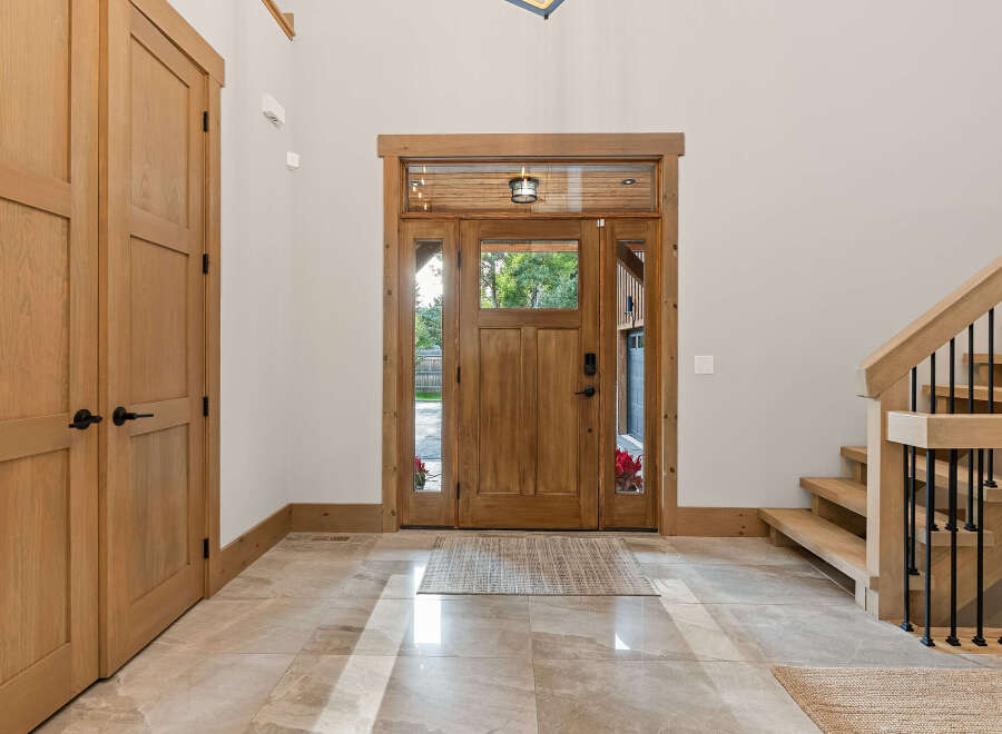 Step into this inviting entryway featuring a beautiful wooden double door with glass panels, allowing natural light to flood the space.
