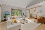 Experience modern living in this spacious living room featuring a large sectional sofa and a cozy leather armchair.
