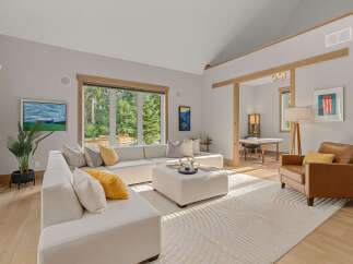 Experience modern living in this spacious living room featuring a large sectional sofa and a cozy leather armchair.