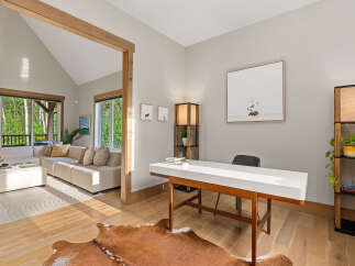 Discover this inviting home office space featuring a sleek white desk and a cozy cowhide rug, perfect for productivity.