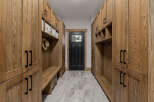 This spacious mudroom features custom oak cabinetry with ample storage and a built-in bench for convenience.