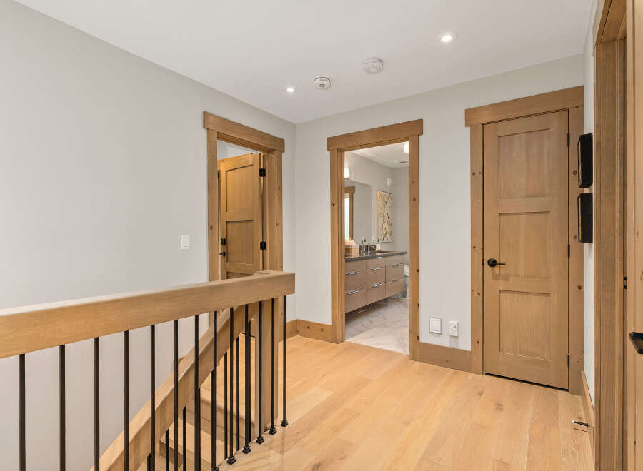 This hallway features natural light and warm wood tones, creating an inviting atmosphere.