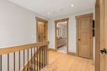This hallway features natural light and warm wood tones, creating an inviting atmosphere.