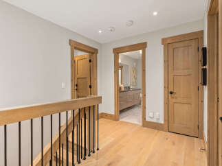 This hallway features natural light and warm wood tones, creating an inviting atmosphere.