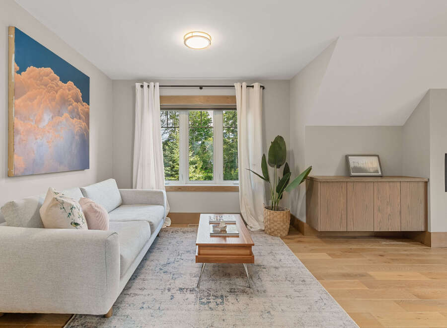 Experience modern living in this beautifully appointed living room, featuring a plush light grey sectional sofa adorned with decorative pillows.