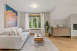 Experience modern living in this beautifully appointed living room, featuring a plush light grey sectional sofa adorned with decorative pillows.