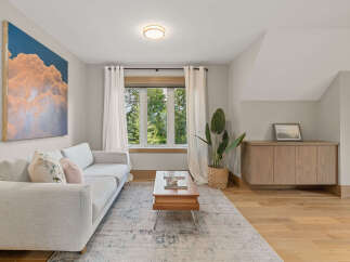 Experience modern living in this beautifully appointed living room, featuring a plush light grey sectional sofa adorned with decorative pillows.