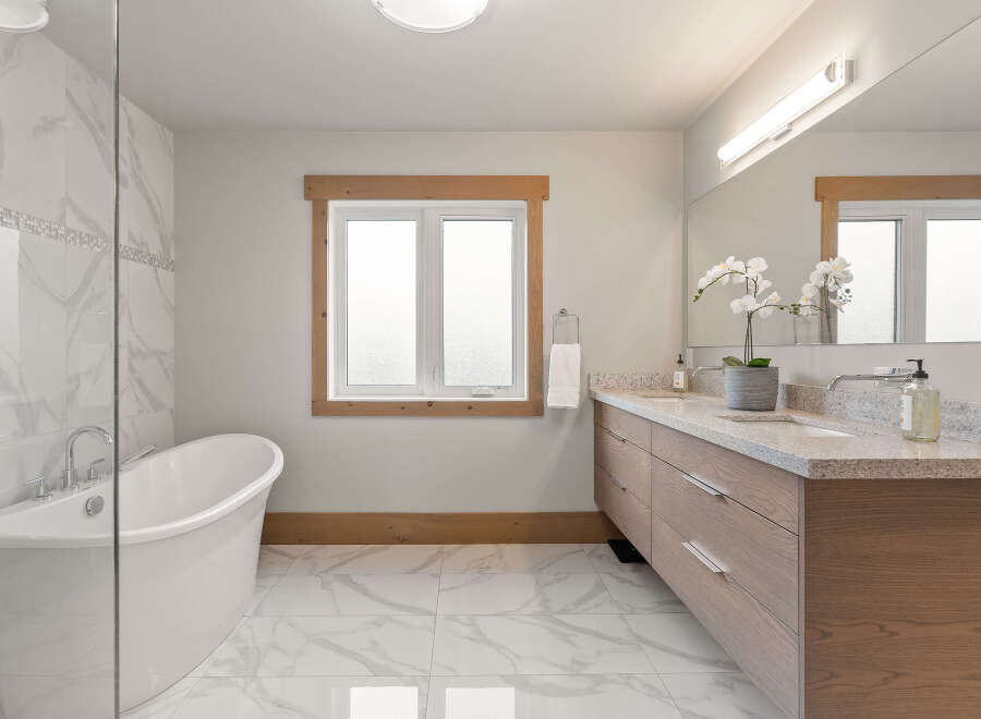 Experience luxury in this stunning bathroom, featuring a freestanding soaking tub perfect for relaxation and a spacious double vanity with granite countertops.