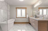 Experience luxury in this stunning bathroom, featuring a freestanding soaking tub perfect for relaxation and a spacious double vanity with granite countertops.