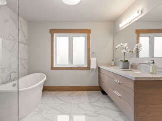 Experience luxury in this stunning bathroom, featuring a freestanding soaking tub perfect for relaxation and a spacious double vanity with granite countertops.