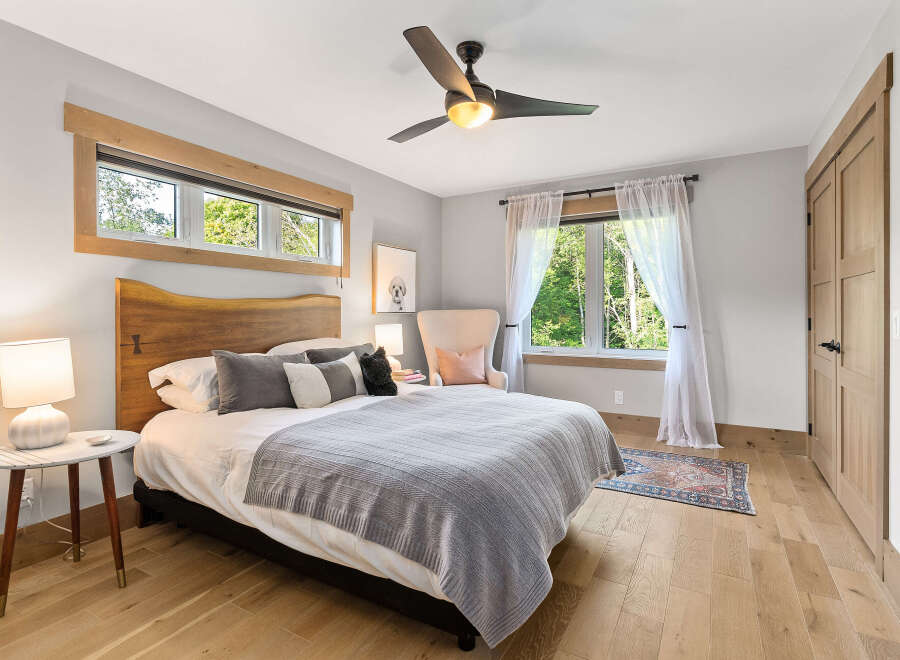 Experience serene comfort in this inviting bedroom, featuring a plush king-sized bed adorned with soft linens and decorative pillows.
