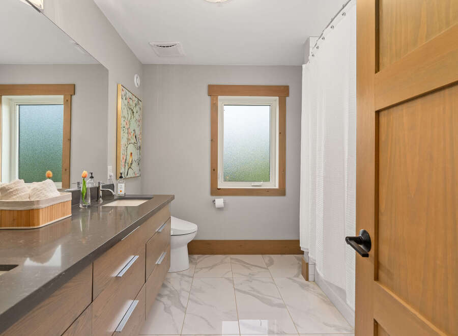 Experience modern comfort in this beautifully appointed bathroom, featuring a sleek vanity with ample storage and a stylish quartz countertop.