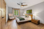 Experience serene living in this beautifully appointed bedroom, featuring a plush armchair and a large window offering picturesque views of lush greenery.