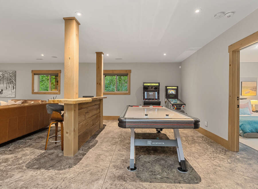 This finished basement offers the ultimate entertainment space, featuring a full-size air hockey table and classic arcade games.